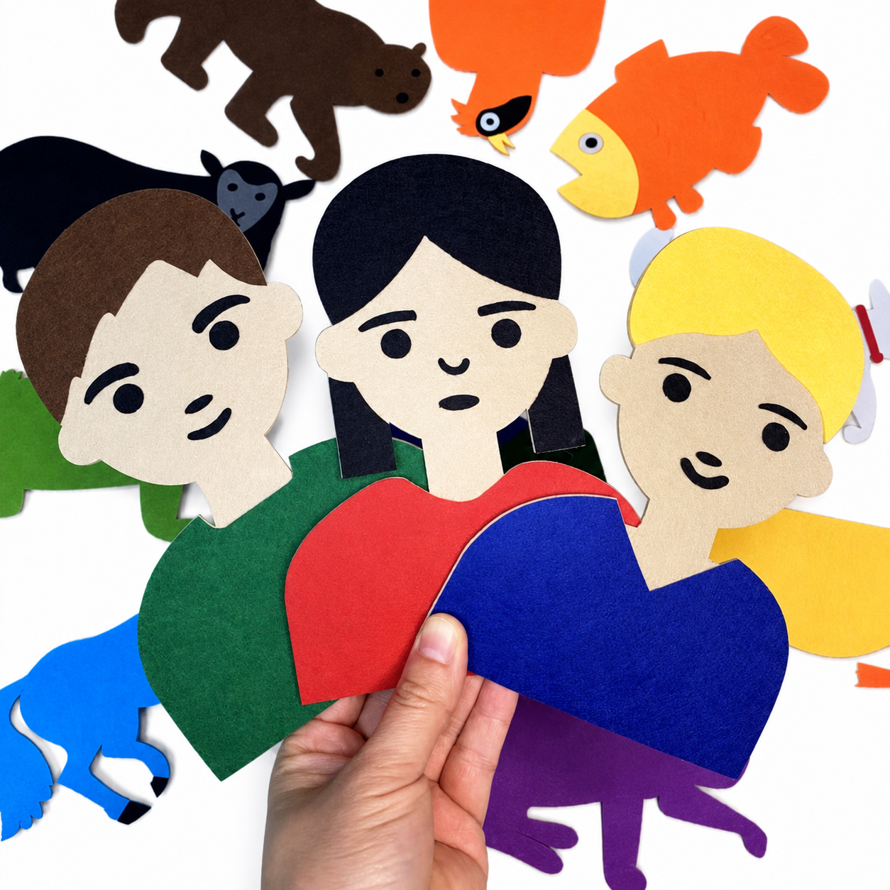 Three colourful felt people pieces held by hand to demonstrate their approximate size