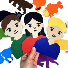 Three colourful felt people pieces held by hand to demonstrate their approximate size